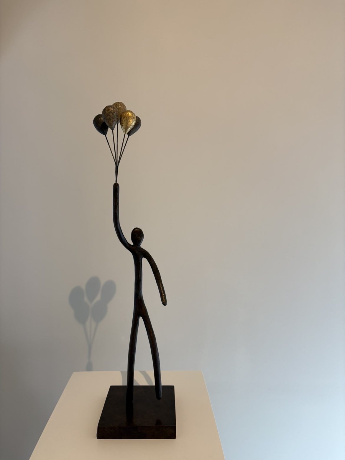 Bronze : personnage tendant un bouquet de ballons dorés