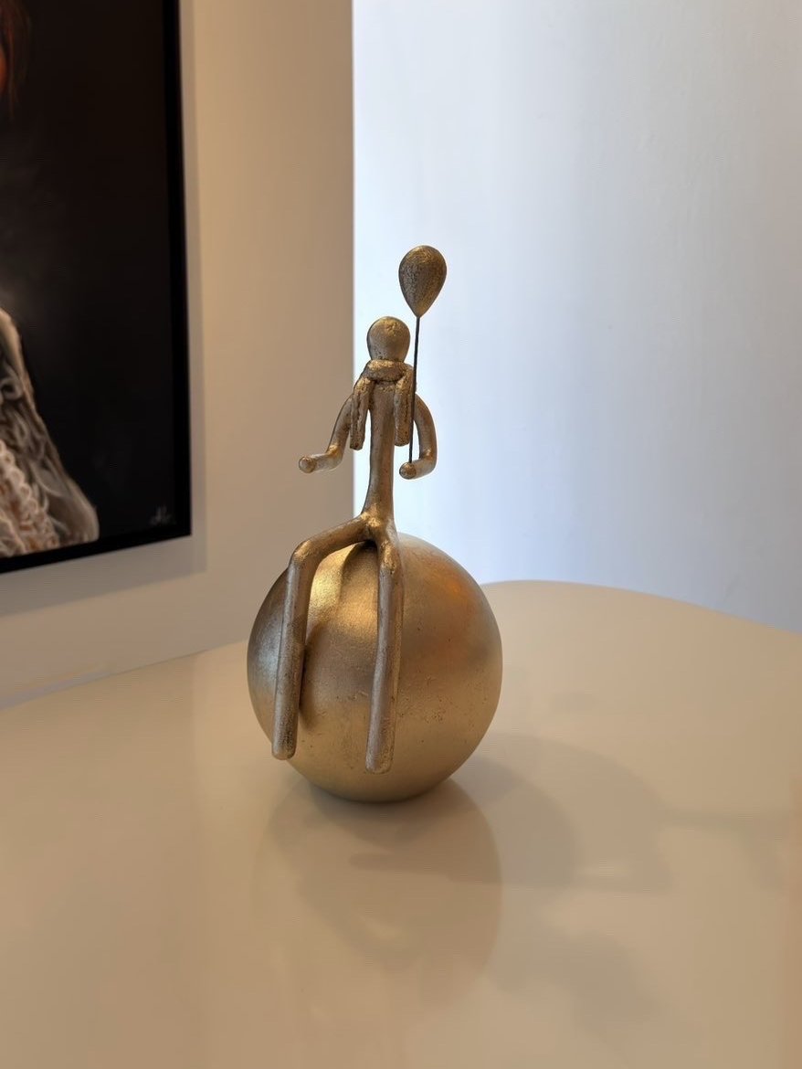 Bronze doré : personnage assis sur une sphère, tenant un ballon